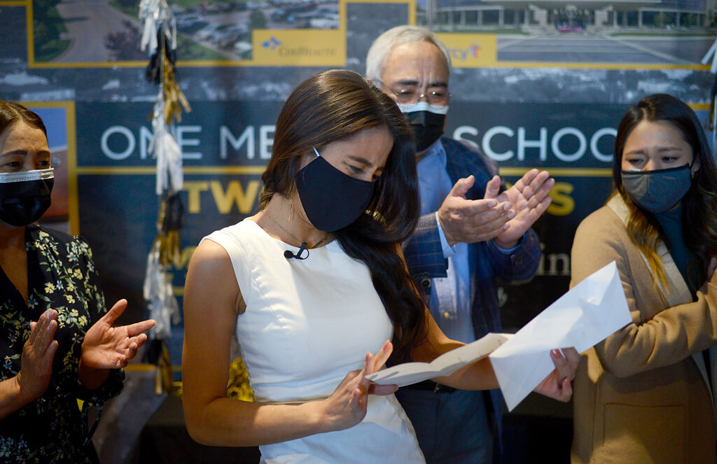 Natalie Rodriguez, center, opens the envelope